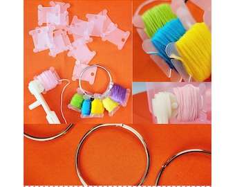 Könnte beinhalten: Ein Set mit bunten Stickgarnrollen, die auf einem Fadenorganisator aus Plastik angeordnet sind. Die Rollen sind in einem Kreis auf einer leuchtend orangenen Oberfläche angeordnet. Der Fadenorganisator besteht aus klarem Plastik und hat einen Ring, um die Rollen an Ort und Stelle zu halten. Das Garn ist in verschiedenen Farben, darunter rosa, lila, grün, gelb und blau.