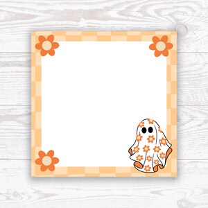 May include: Square notepad with an orange and white checkered border and orange flower accents. A cartoon ghost wearing a floral patterned sheet is in the lower right corner. The notepad is on a white wooden surface.