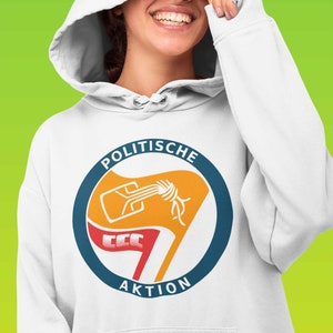 Peut inclure: Sweat-shirt à capuche blanc avec un graphique circulaire bleu et orange représentant un drapeau stylisé avec le texte "POLITISCHE AKTION".