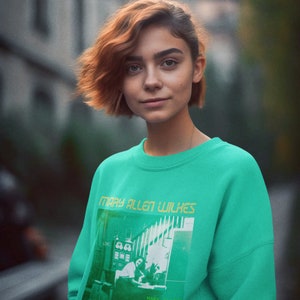Peut inclure: Un sweat-shirt vert turquoise avec un imprimé graphique de Mary Allen Wilkes, une programmeuse informatique, et le texte "Programmeuse chez LINC, le premier ordinateur personnel".