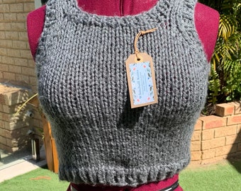 Hand made vest. We hand knitted this vest in easy care acrylic yarn. Chunky, soft and cuddly. Small and fitted.