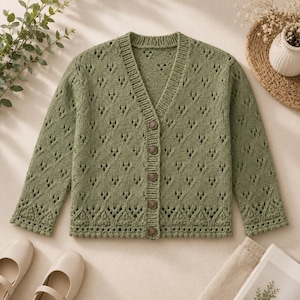 Peut inclure: Un cardigan en tricot vert sauge doté d'un col en V, de manches longues et d'une fermeture boutonnée sur le devant. Le vêtement présente un motif en dentelle ajourée sur tout le corps et les manches, avec un col et des bords côtelés.