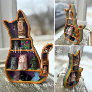 May include: A cat-shaped shelf with rainbow edges and orange trim, holding various small figurines and glass bottles. The shelf is painted with purple and orange, and the figurines are in various colors and shapes.