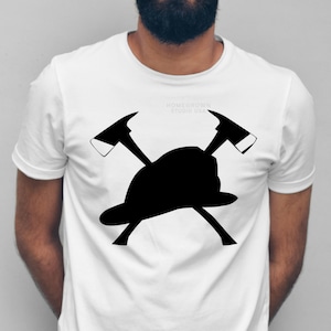 May include: White t-shirt with a black silhouette of a firefighter's helmet and two crossed axes. The text "Homegrown Studio USA" is printed on the shirt.