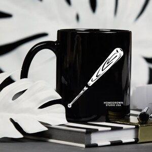 May include: Black ceramic mug with a white baseball bat graphic and the text "Homegrown Studio USA".