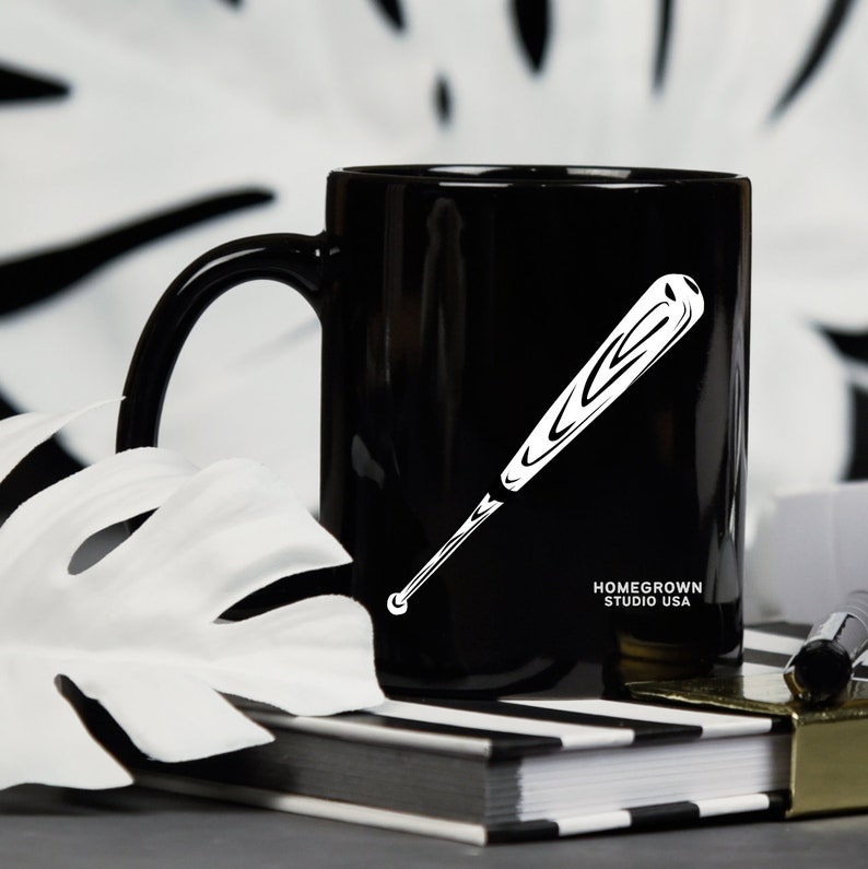 May include: Black ceramic mug with a white baseball bat graphic and the text "Homegrown Studio USA".