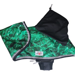 May include: Green and black dog harness with a reflective strip and a zippered pouch. The harness has a water-like pattern and the text "ZIP IT PUP" is printed on the front.