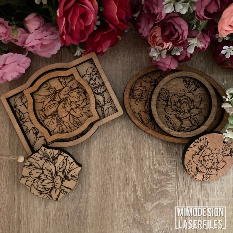 May include: Set of four wooden coasters with a floral design. The coasters are in different shapes and sizes, and they are all made of a light brown wood. The coasters are arranged on a wooden surface.