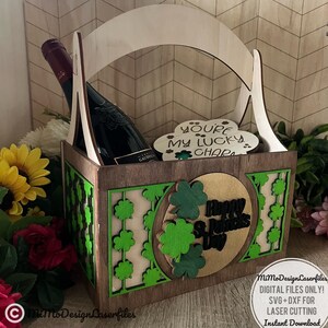 Può includere: Un cesto regalo in legno con un design a trifoglio verde e il testo "Buon San Patrizio". Il cesto è pieno di una bottiglia di vino e un cartello in legno che dice "Sei il mio portafortuna".