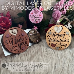 Puede incluir: Tres adornos de madera cortados con láser con temas del Día de San Valentín. El primer adorno es marrón con el texto "You're sweet" y "I love you" en forma de corazón. El segundo adorno es marrón con el texto "Happy Valentine's Day". El tercer adorno es rosa con el texto "You're sweet" y "I love you".