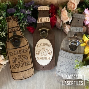 Può includere: Tre supporti a parete in legno per apribottiglie a forma di bottiglie di birra. Ogni apribottiglie ha il testo "ICE COLD BEER SERVED HERE" e una grafica con il pollice in su. L'apribottiglie al centro ha il testo "BEER" e "OPEN HERE" sul davanti.