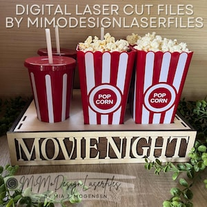 Può includere: Un set per la serata cinema con contenitori di popcorn a strisce rosse e bianche pieni di popcorn, bicchieri rossi con cannucce e un vassoio di legno con le parole "MOVIE NIGHT". L'immagine include anche il testo "DIGITAL LASER CUT FILES BY MIMODESIGNLASERFILES".