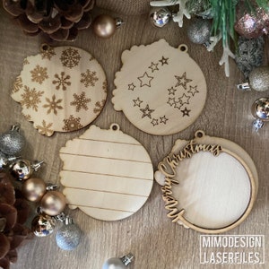 Op de afbeelding: Vier onafgewerkte houten kerstversieringen. Een versiering heeft een sneeuwvlokkenontwerp, een andere een sterontwerp, een heeft een gestreept ontwerp en de laatste heeft de tekst "Merry Christmas" en een cirkel in het midden.