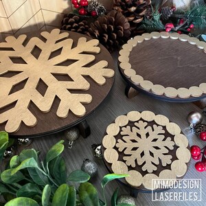 Può includere: Tre espositori in legno a tre livelli con motivi a fiocco di neve dorati. Gli espositori sono perfetti per esporre decorazioni natalizie o altri piccoli oggetti.