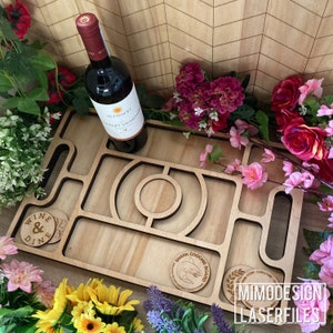 Op de afbeelding: Een houten serveerblad met een haai-ontwerp en de tekst "Shark Coochie Board". Het dienblad heeft meerdere compartimenten en is perfect om snacks en drankjes te serveren. Het dienblad is omringd door bloemen.
