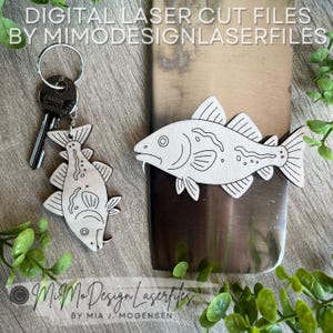 Può includere: Portachiavi a forma di pesce in legno e pesce decorativo. Il portachiavi ha un anello di metallo con chiavi attaccate. I disegni dei pesci sono tagliati al laser con contorni dettagliati. Il testo "DIGITAL LASER CUT FILES BY MIMODESIGNLASERFILES" è in alto.