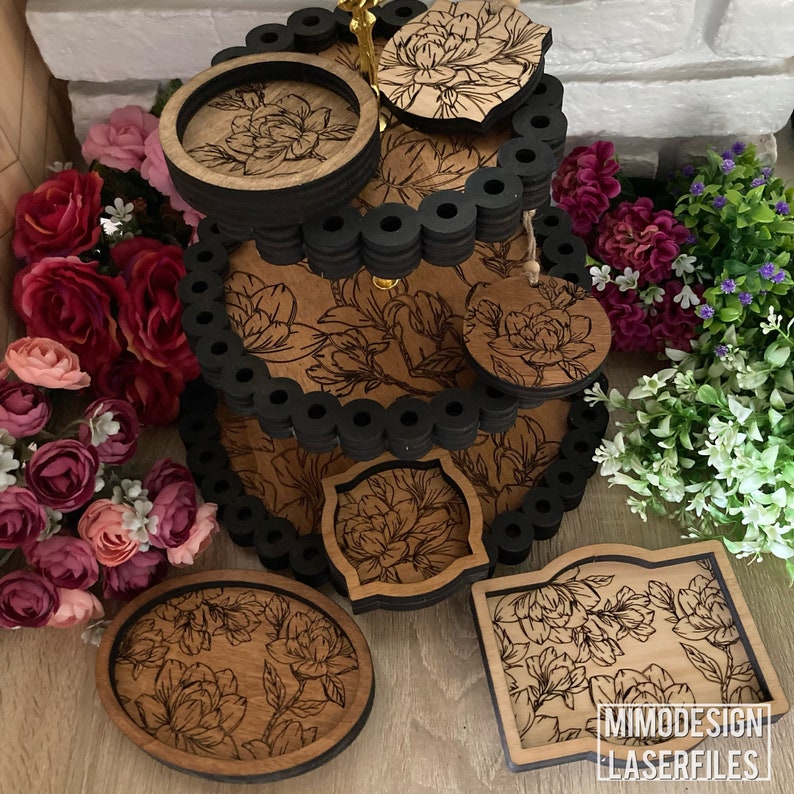 May include: A three-tiered wooden serving tray with black trim and floral designs. Each tier has a round shape and features a different floral pattern. The tray is perfect for serving snacks, desserts, or drinks.