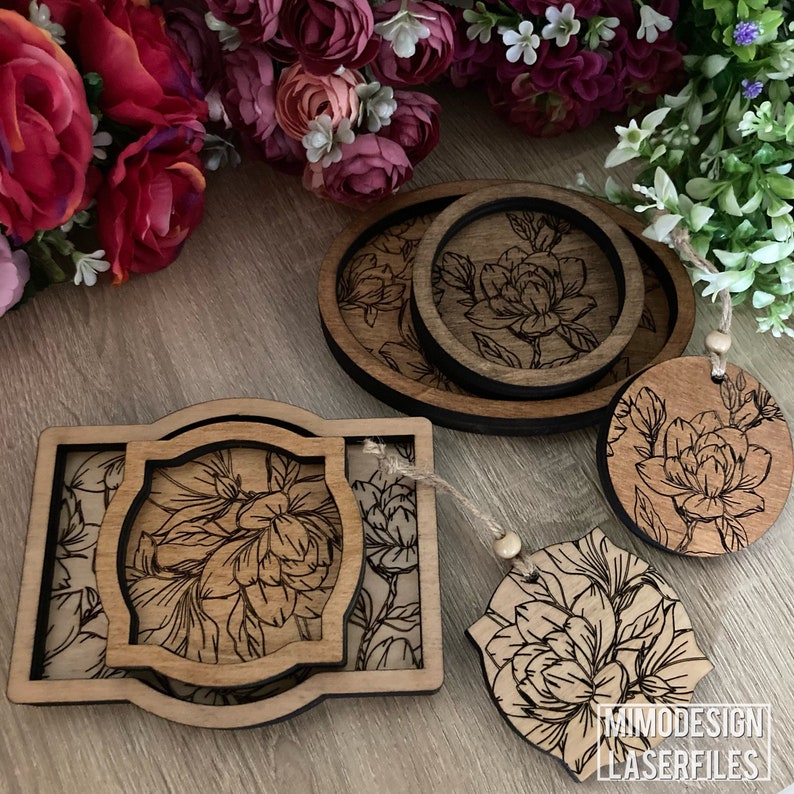 May include: Set of four wooden coasters with a floral design. The coasters are in various sizes and shapes, including a round coaster, a square coaster, and an oval coaster. The coasters are all made of natural wood and have a dark brown stain. The coasters are perfect for adding a touch of elegance to any home.
