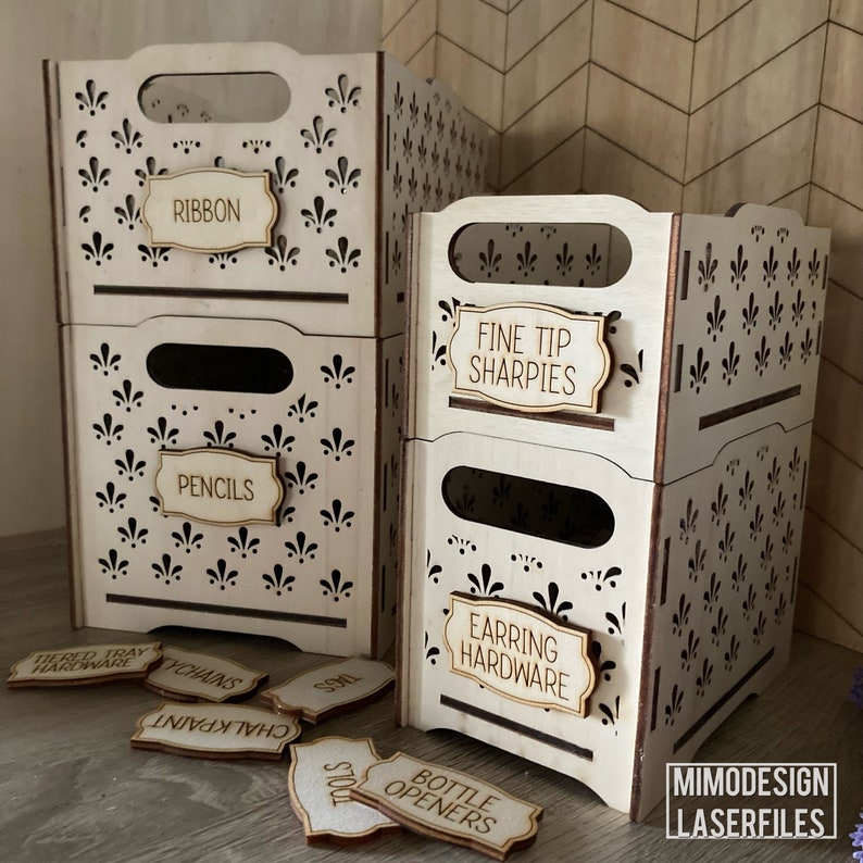 May include: Three wooden storage boxes with cut-out designs and labels. The labels read "Ribbon", "Fine Tip Sharpies", and "Earring Hardware".