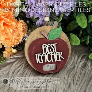May include: A red apple with a green leaf and the words "Best Teacher You" on it. The apple is on a wooden background.