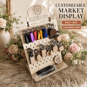 May include: A light-colored wooden pegboard display stand featuring various keychains, including metal bottle openers in black, purple, red, and yellow, and plain wooden shapes. The display includes text reading CUSTOMIZABLE MARKET DISPLAY, SVG + DXF, and 4 MATERIAL SIZES.