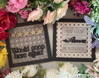 May include: Two wooden signs with black frames and a woven pattern. The first sign says "Would poop here again" with five gold stars. The second sign says "May your llama be with you".