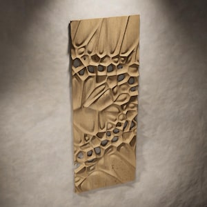 May include: A rectangular, light brown wooden wall art piece with a carved, organic design. The artwork features a series of interconnected, textured shapes and open spaces, creating a three-dimensional effect. The piece is approximately 30 cm wide and 61 cm tall.