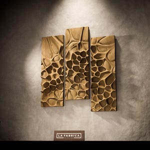 May include: Three rectangular wooden wall art panels with a carved, organic pattern. The panels are a warm brown color and are mounted on a gray wall. The panels are arranged vertically and have a textured surface.