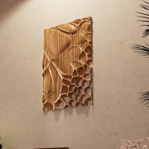 May include: A wooden wall sculpture with a unique, organic design. The sculpture is made of light brown wood and has a textured surface. It features a series of interconnected holes and curves, creating a visually interesting and abstract piece.