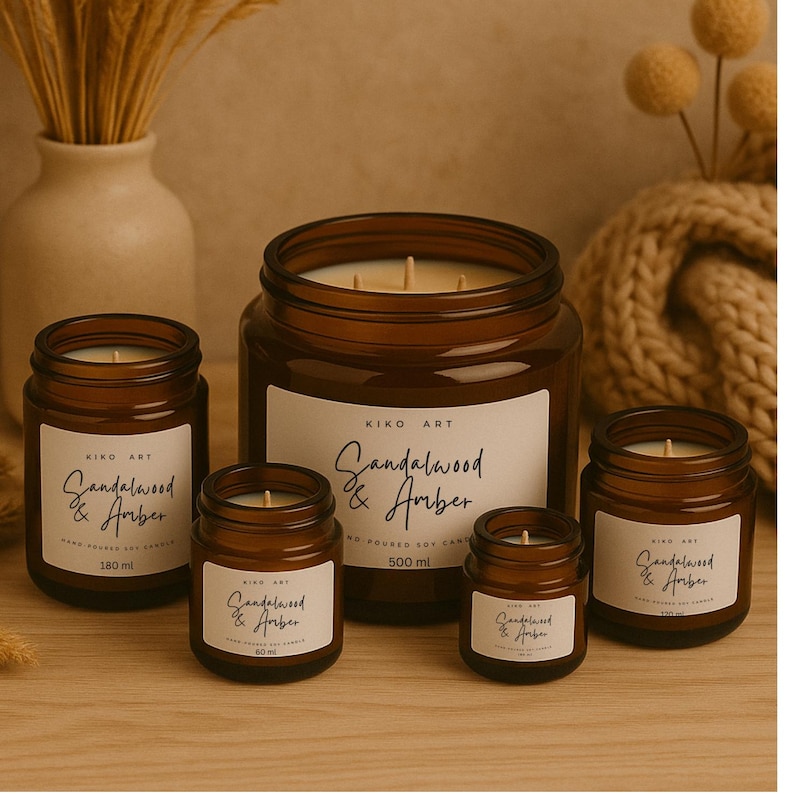 Op de afbeelding: Een verzameling bruine glazen potkaarsen met witte etiketten. De etiketten lezen "Sandalwood & Amber" en bevatten het volume in ml. De kaarsen vari&euml;ren in grootte, de grootste bevat 500 ml.