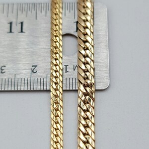 Op de afbeelding: Twee gouden kettingen van verschillende breedtes naast een liniaal. De kettingen zijn beide 11 inch lang.