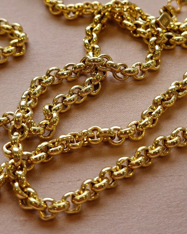 May include: A gold chain necklace with a thick, round link design. The chain is made of polished metal and has a shiny finish.