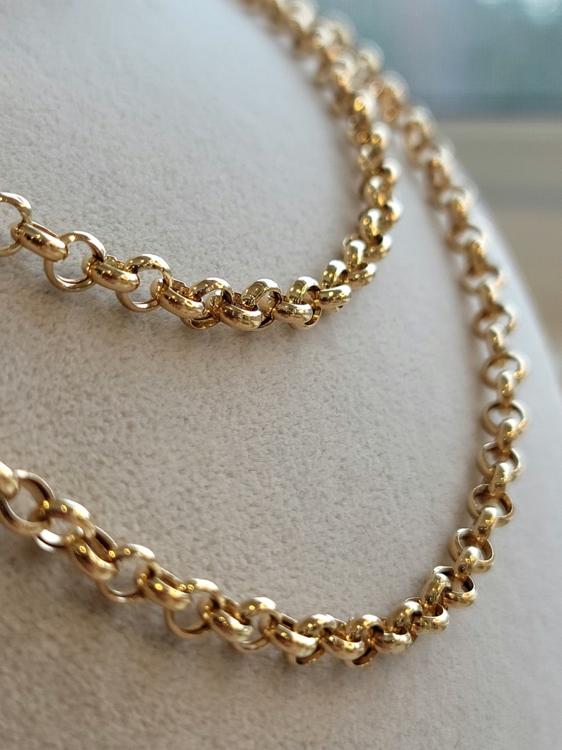 May include: A gold chain necklace with a delicate, round link design. The chain is displayed on a white background.