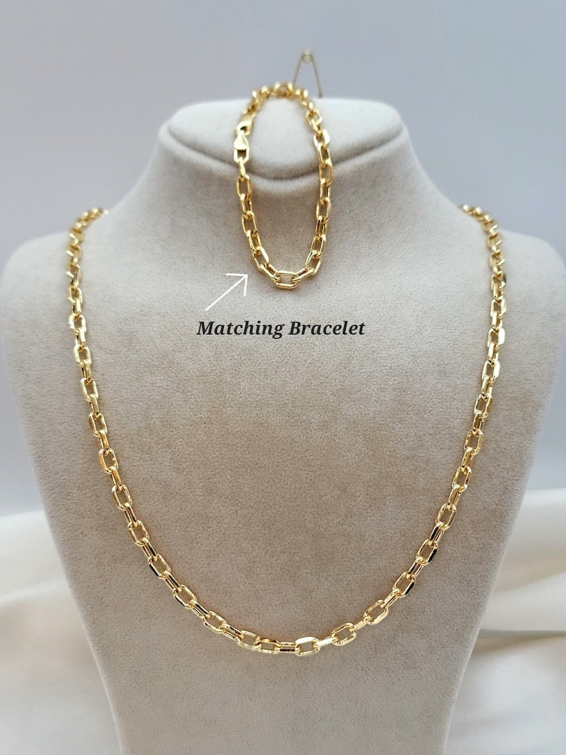 Puede incluir: Un collar de cadena dorada con una pulsera de cadena dorada a juego. La pulsera est&aacute; colocada sobre el collar y acompa&ntilde;ada por una flecha blanca que apunta hacia ella con el texto Matching Bracelet escrito en negro.