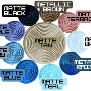 May include: A collection of spiral-patterned coasters in various colors, including matte black, purple, gray, blue, and teal. Other colors include metallic brown and rainbow. Each coaster has a label with its color name.