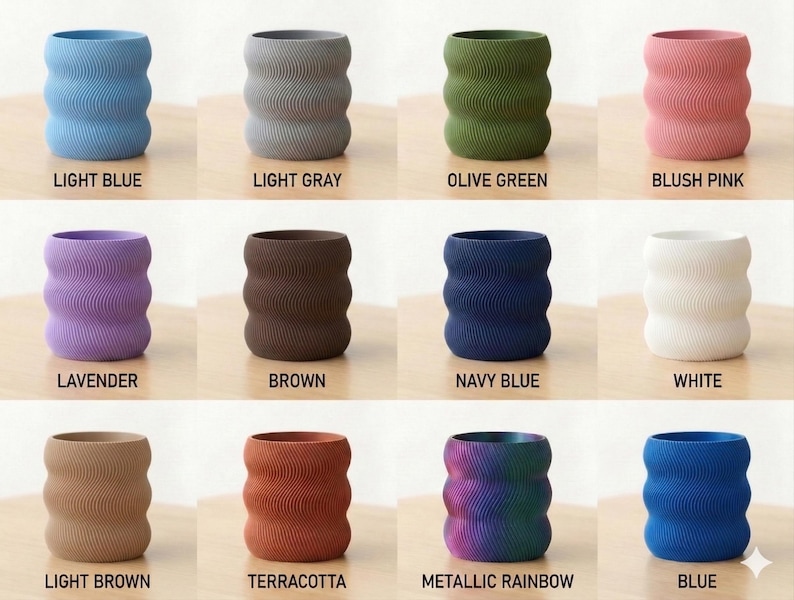 Op de afbeelding: Een verzameling keramische vazen in verschillende kleuren, waaronder lichtblauw, lichtgrijs, olijfgroen, blush roze, lavendel, bruin, marineblauw, wit, lichtbruin, terracotta, metallic regenboog en blauw. Elke vaas heeft een golvend, getextureerd ontwerp.