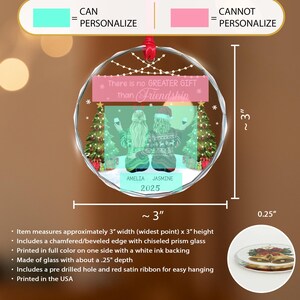 May include: A clear glass friendship ornament, approximately 3 inches wide and 3 inches high, with a red ribbon for hanging. The ornament features a design with two figures, the text "There is no GREATER GIFT than Friendship", and the names AMELIA and JASMINE, with the year 2025.