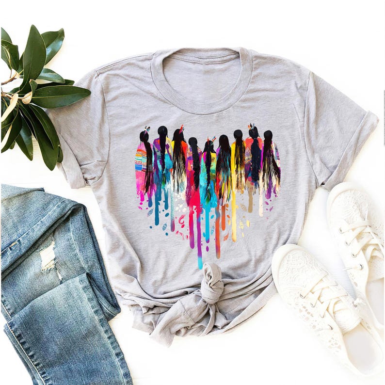 May include: A gray t-shirt with a colorful graphic of women standing in a heart shape. The graphic is made up of colorful paint splatters.