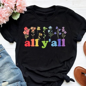 May include: Black t-shirt with a rainbow floral design and the text "all y'all" in rainbow letters.