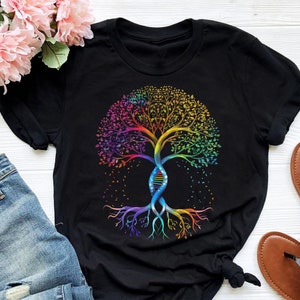 Puede incluir: Camiseta negra con un diseño de árbol colorido. El tronco del árbol es una doble hélice, que simboliza el ADN. Las hojas son en tonos de rojo, naranja, amarillo, verde, azul y morado.