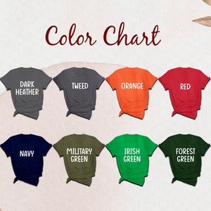 Puede incluir: Una carta de colores con doce camisetas de manga corta en varios colores etiquetadas como Black, Dark Heather, Tweed, Orange, Red, Maroon, Lilac, Navy, Military Green, Irish Green, Forest Green y Dark Chocolate, dispuestas en dos filas.