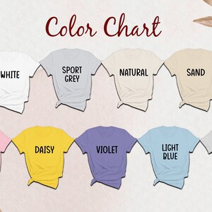 Puede incluir: Una carta de colores que muestra nueve camisetas de manga corta en varios colores, cada una etiquetada con texto: White, Sport Grey, Natural, Sand, Light Pink, Daisy, Violet, Light Blue e Ice Grey. Las camisetas est&aacute;n dispuestas en dos filas.