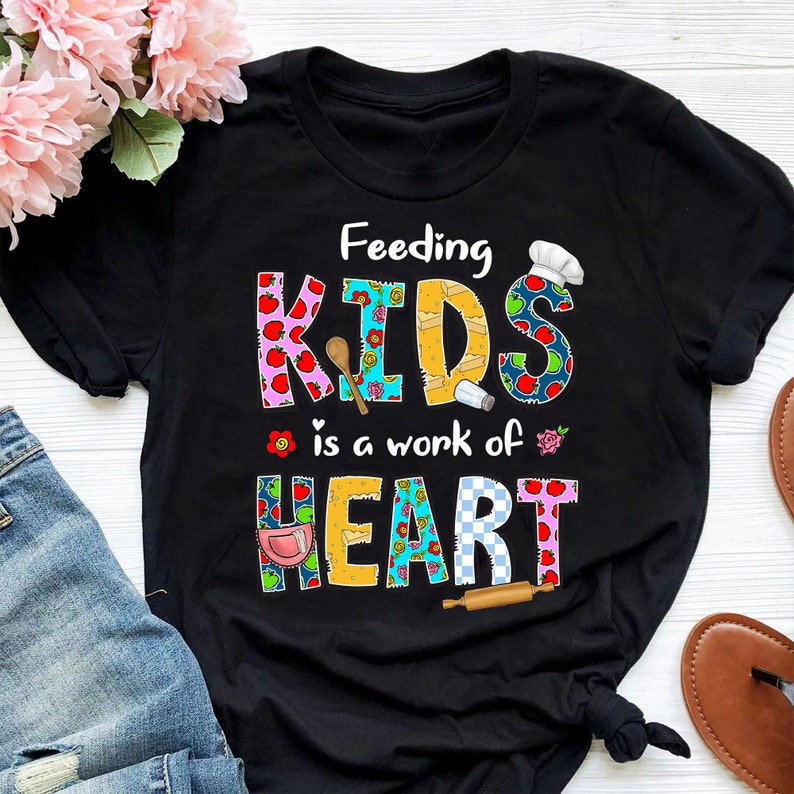 May include: Black t-shirt with a colorful patchwork design that says "Feeding Kids is a work of Heart".