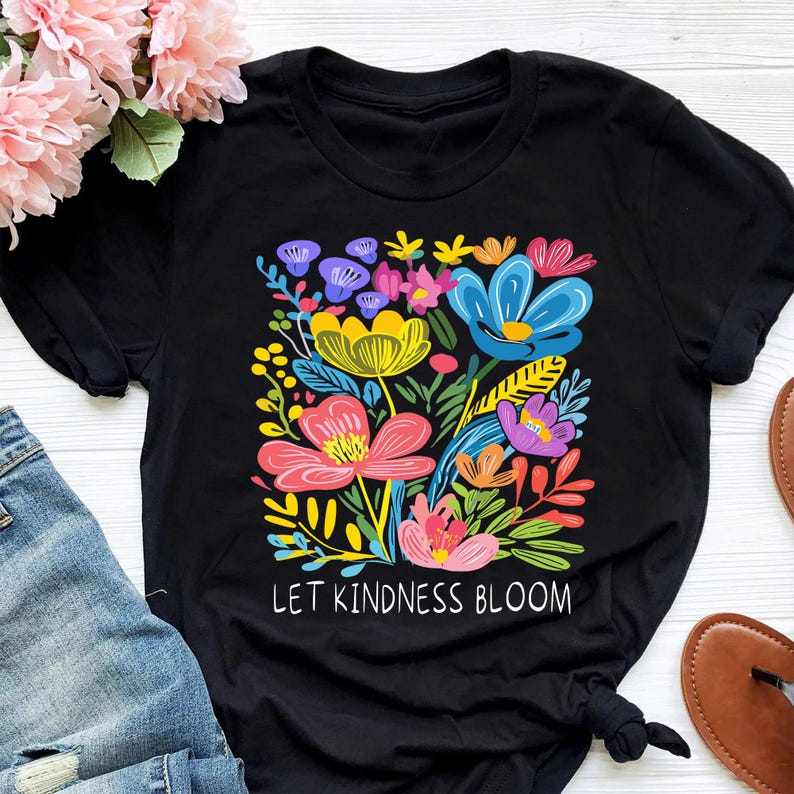 May include: Black t-shirt with a colorful floral design and the text "Let Kindness Bloom".