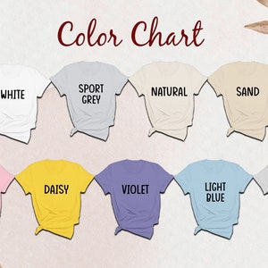 May include: Color chart showing ten different t-shirt colors: white, sport grey, natural, sand, light pink, daisy, violet, light blue, ice grey.