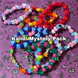 Könnte beinhalten: Eine Sammlung bunter Kandi-Armbänder mit Stern-, Herz- und runden Perlen. Die Armbänder sind in verschiedenen Farben erhältlich, darunter Rosa, Blau, Grün und Orange. Der Text "Kandi Mystery Pack" ist auf dem Bild zu sehen.