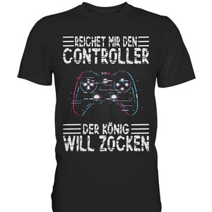 May include: Black t-shirt with a white graphic of a video game controller and the text "Reichet mir den Controller Der König Will Zocken".