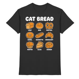 Könnte beinhalten: Schwarzes T-Shirt mit dem Text "CAT BREAD" und Illustrationen verschiedener Brotsorten, jede mit einem Katzengesicht. Die Brotsorten umfassen Brotlaib, Brötchen, Brezel, Bagel, Baguette, Croissant, Muffin, Scheibe und Dänisch.