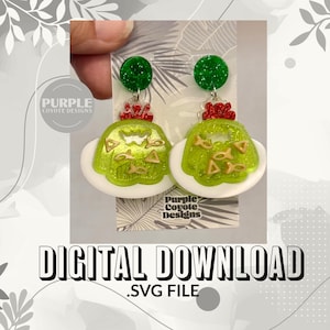 Peut inclure: Boucles d'oreilles faites à la main avec un design original. Elles présentent une forme verte et scintillante ressemblant à un plat, sur une base blanche, avec des accents rouges et verts. Le texte "DIGITAL DOWNLOAD .SVG FILE" est visible en bas.