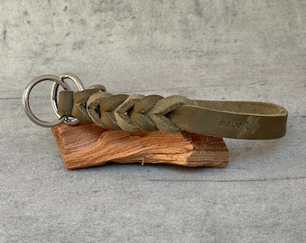 May include: A green leather braided key chain with a silver key ring and the word "mangrove" embossed on the leather.